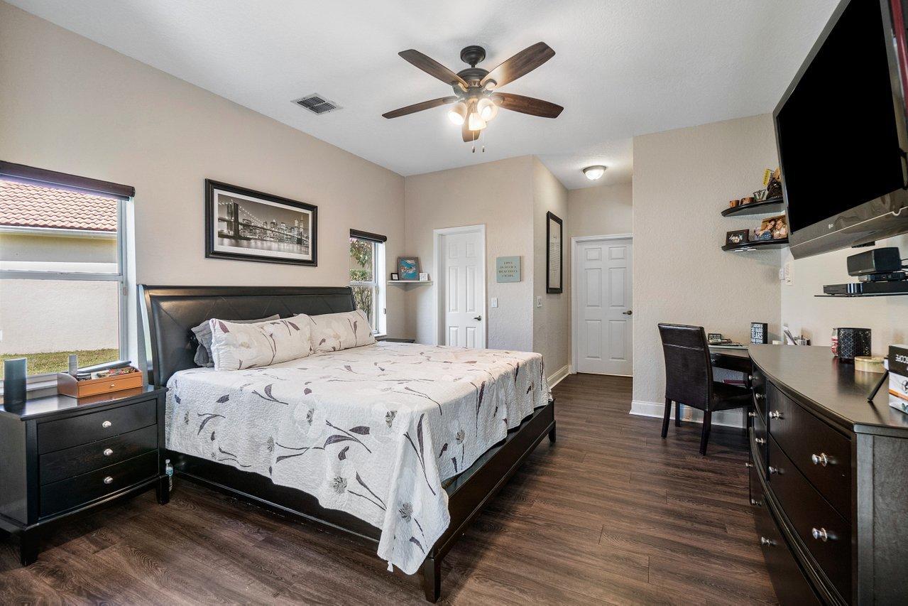 10921 Haydn Drive Boca Raton, FL 33498 - Photo 24 of 45 a spacious bedroom with a bed and a flat screen tv