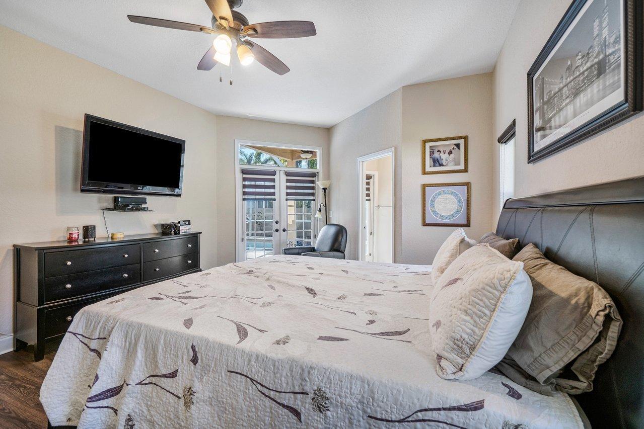 10921 Haydn Drive Boca Raton, FL 33498 - Photo 29 of 45 a bedroom with a bed and a flat screen tv