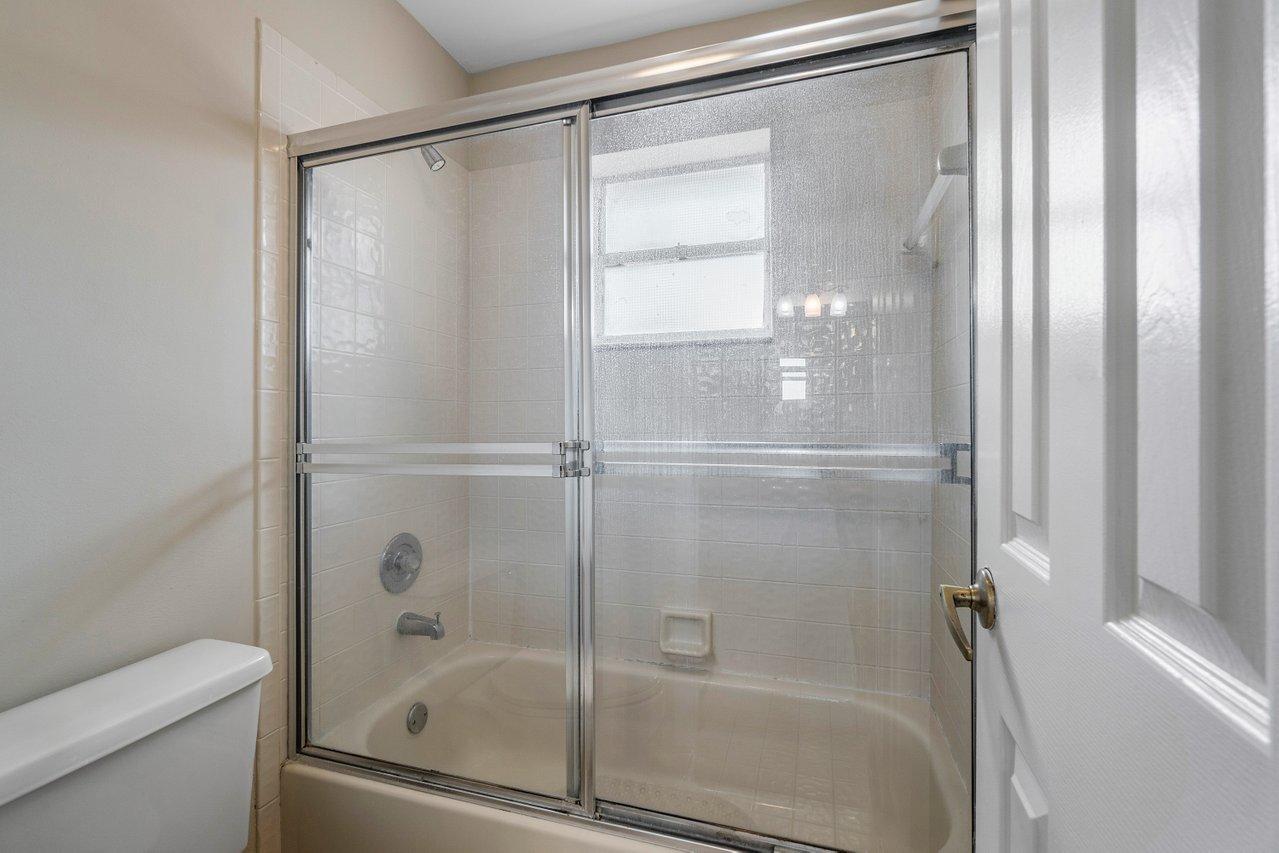 10921 Haydn Drive Boca Raton, FL 33498 - Photo 33 of 45 a bathroom with a glass shower door