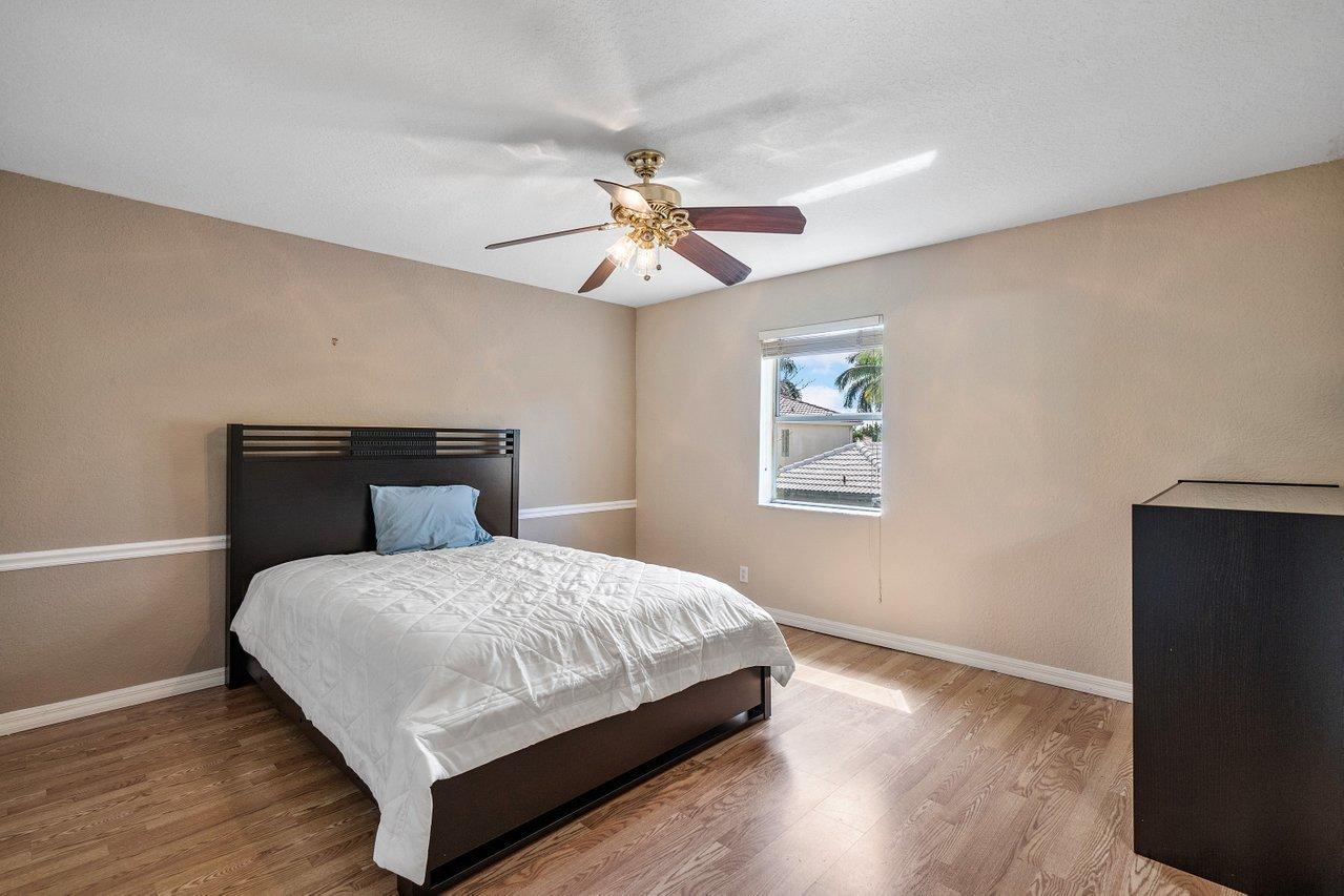 10921 Haydn Drive Boca Raton, FL 33498 - Photo 34 of 45 a bedroom with a bed and a chandelier