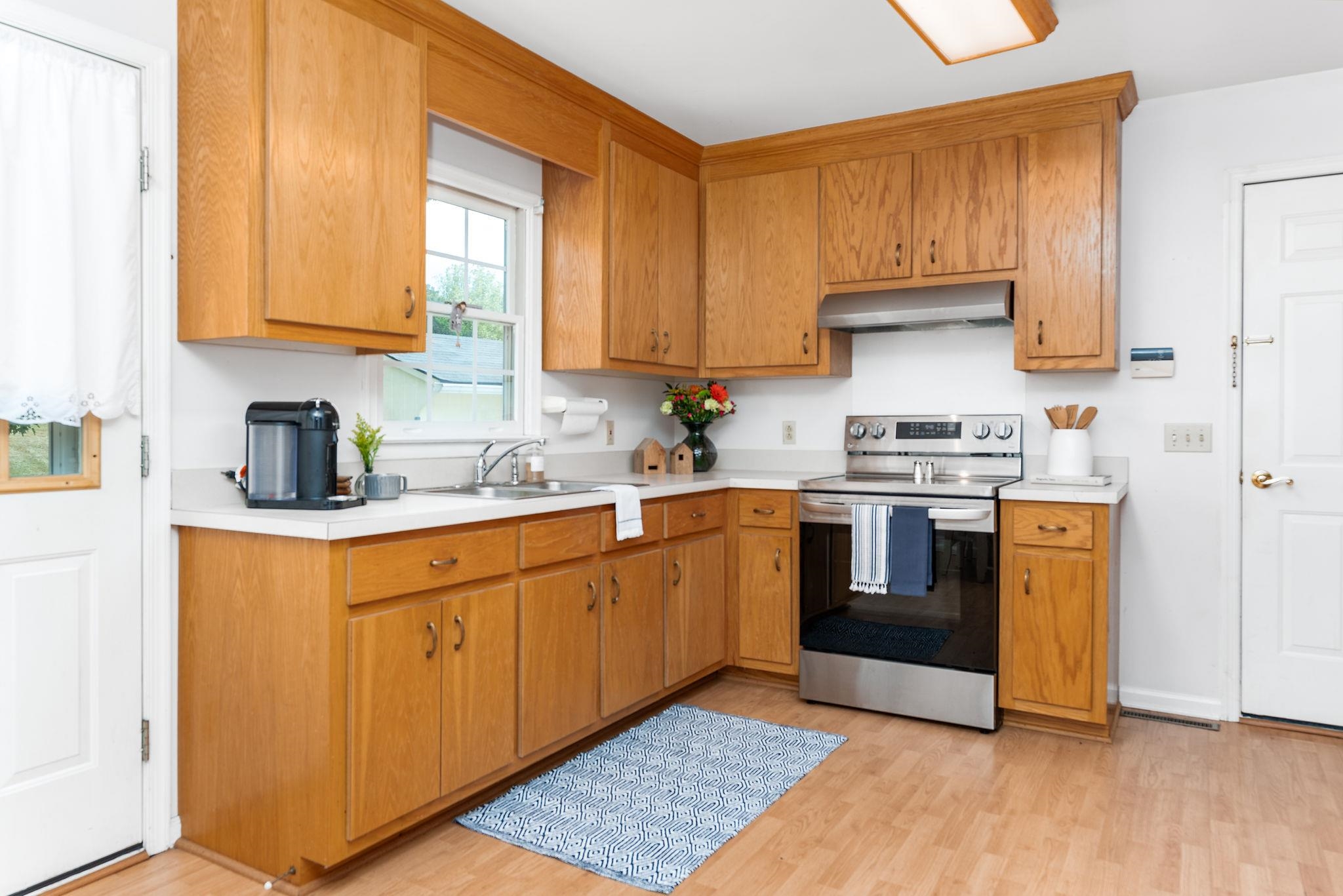 479 Battlefield Road Fort Defiance, VA 24437 - Photo 14 of 51 a kitchen with stainless steel appliances granite countertop a sink a stove a refrigerator cabinets and a window