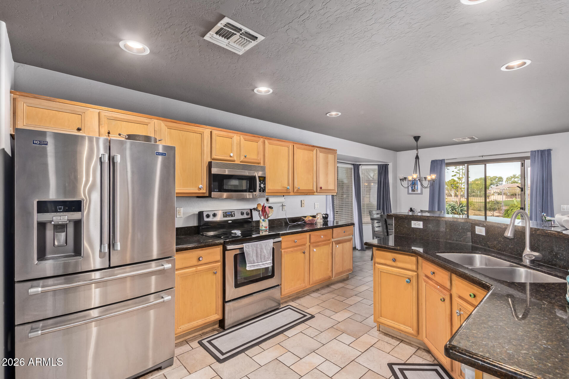 22838 South Legends Road Queen Creek, AZ 85142 - Photo 8 of 22 a kitchen with stainless steel appliances granite countertop a refrigerator a stove a sink and a microwave