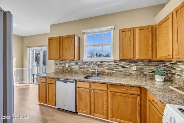 a kitchen with stainless steel appliances granite countertop white cabinets and wooden floor