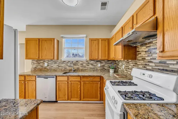 a bathroom with a granite countertop toilet sink and mirror