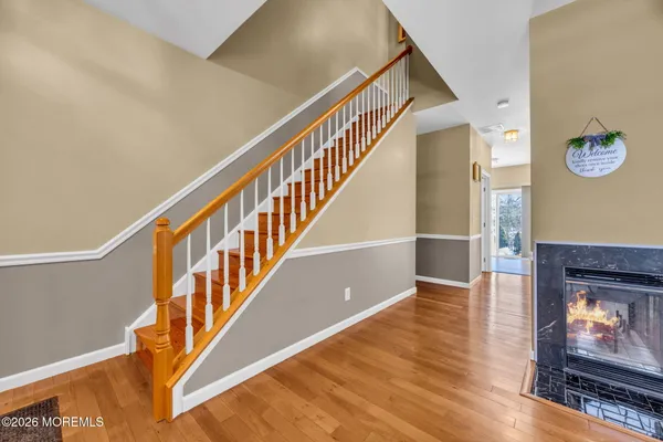 a view of a kitchen with kitchen island granite countertop wooden floor and stainless steel appliances