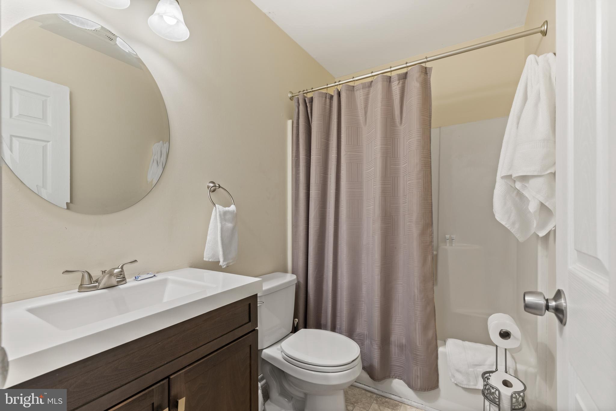 276 Broad Street Highspire, PA 17034 - Photo 18 of 28 a bathroom with a sink a toilet a mirror and shower curtain