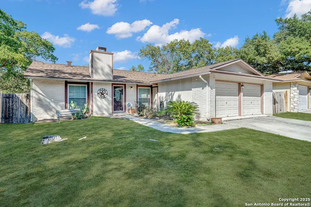 a front view of a house with a garden and plants