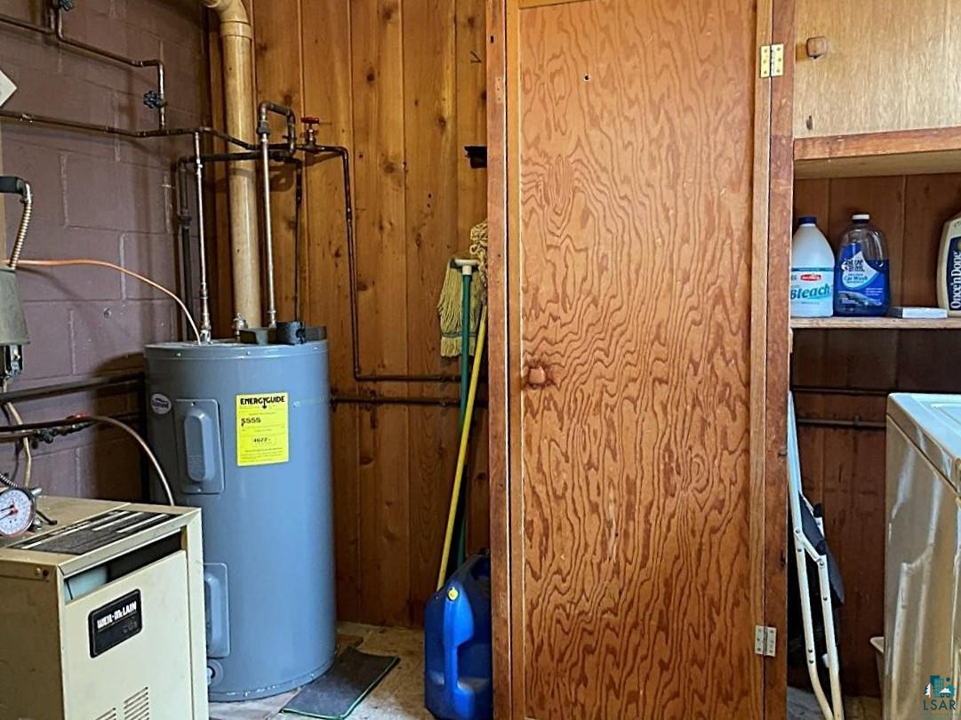 1480 Maijala Road Ely, MN 55731 - Photo 34 of 58 Utility area featuring a water heater, boiler, and wooden storage cabinet
