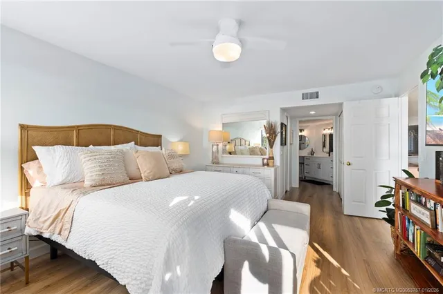 a bedroom with a bed wooden floor and lamp