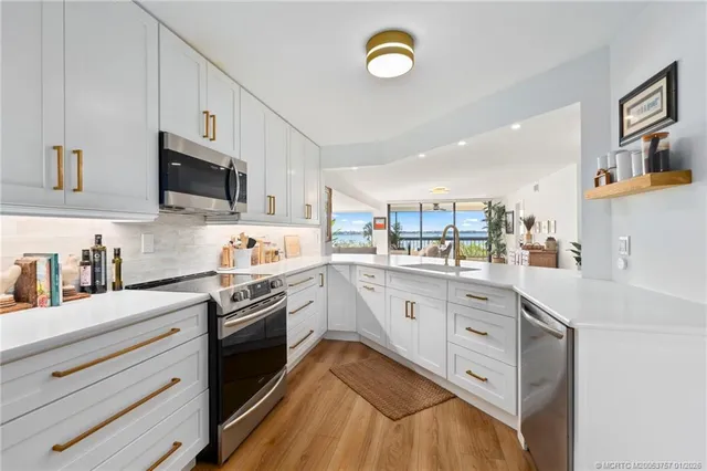 a kitchen with stainless steel appliances cabinets and wooden floor