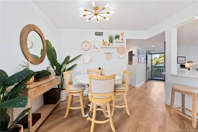 a dining room with furniture and a potted plant