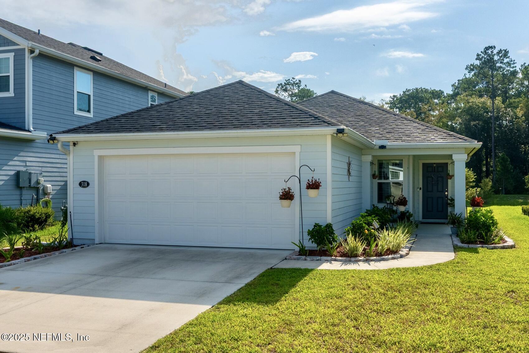 318 Rambling Brk Trail St. Johns, FL 32259 - Photo 4 of 26 a front view of a house with a yard and potted plants