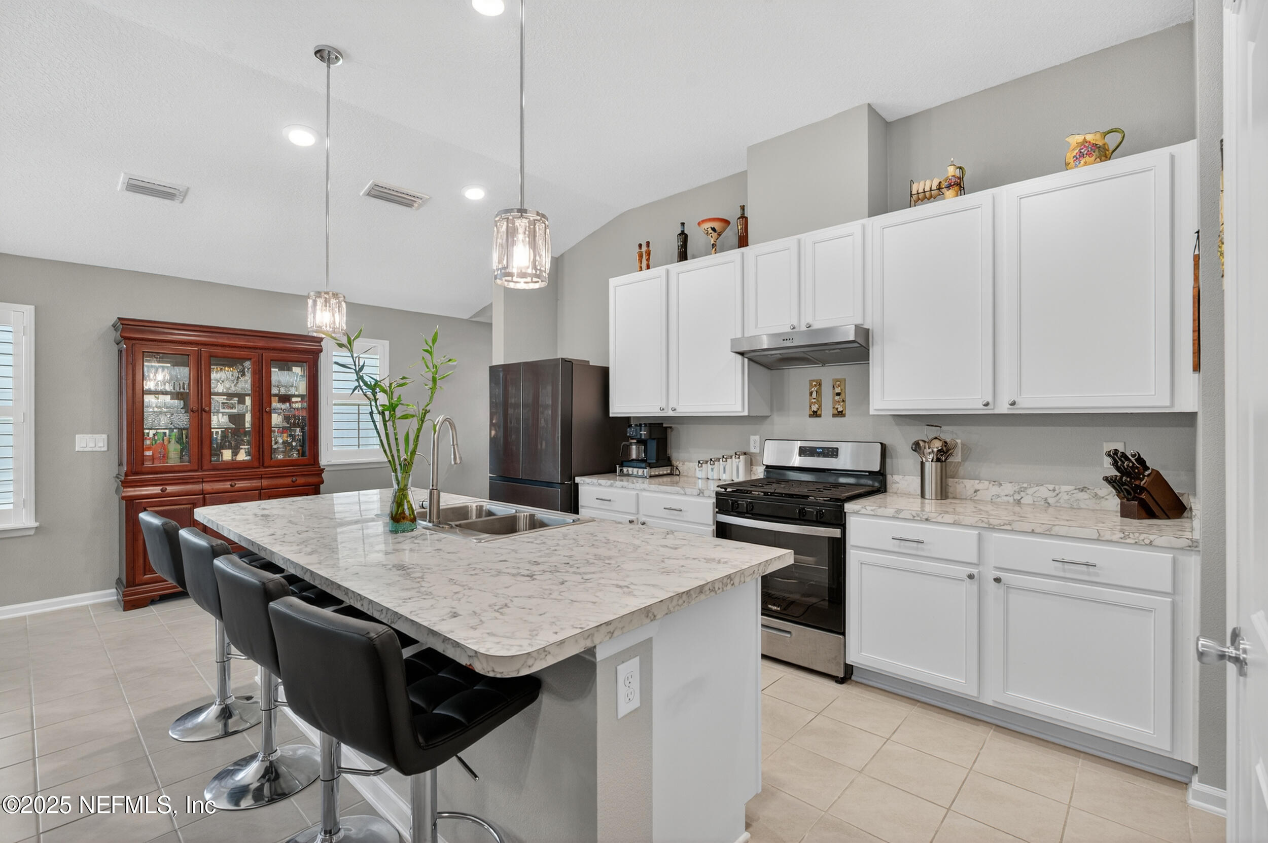 318 Rambling Brk Trail St. Johns, FL 32259 - Photo 7 of 26 a kitchen with granite countertop a sink a center island stainless steel appliances and cabinets
