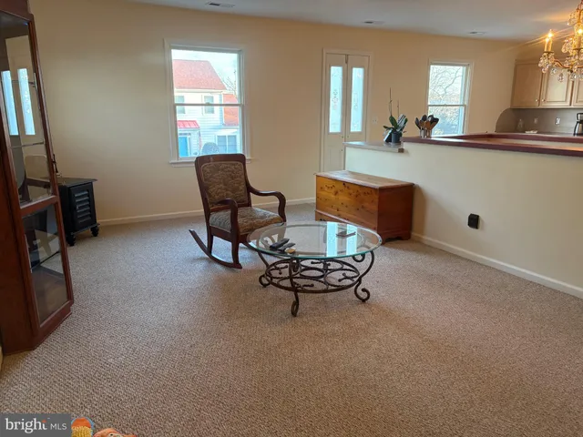 a living room with furniture a fireplace and a chandelier