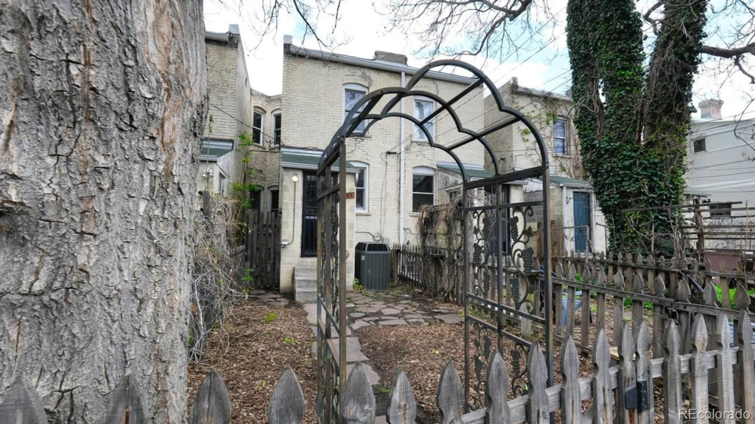 553 Logan Street Denver, CO 80203 - Photo 14 of 38 a view of a house with large trees and wooden fence