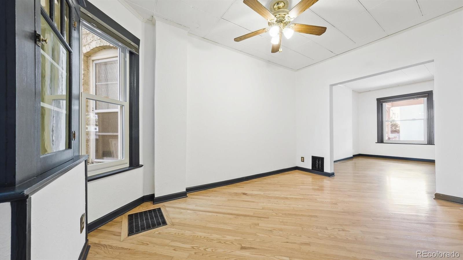 553 Logan Street Denver, CO 80203 - Photo 17 of 38 a view of an empty room with a window and a kitchen view