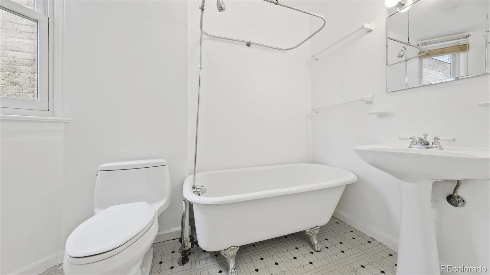 553 Logan Street Denver, CO 80203 - Photo 20 of 38 a bathroom with a white toilet a sink and bathtub