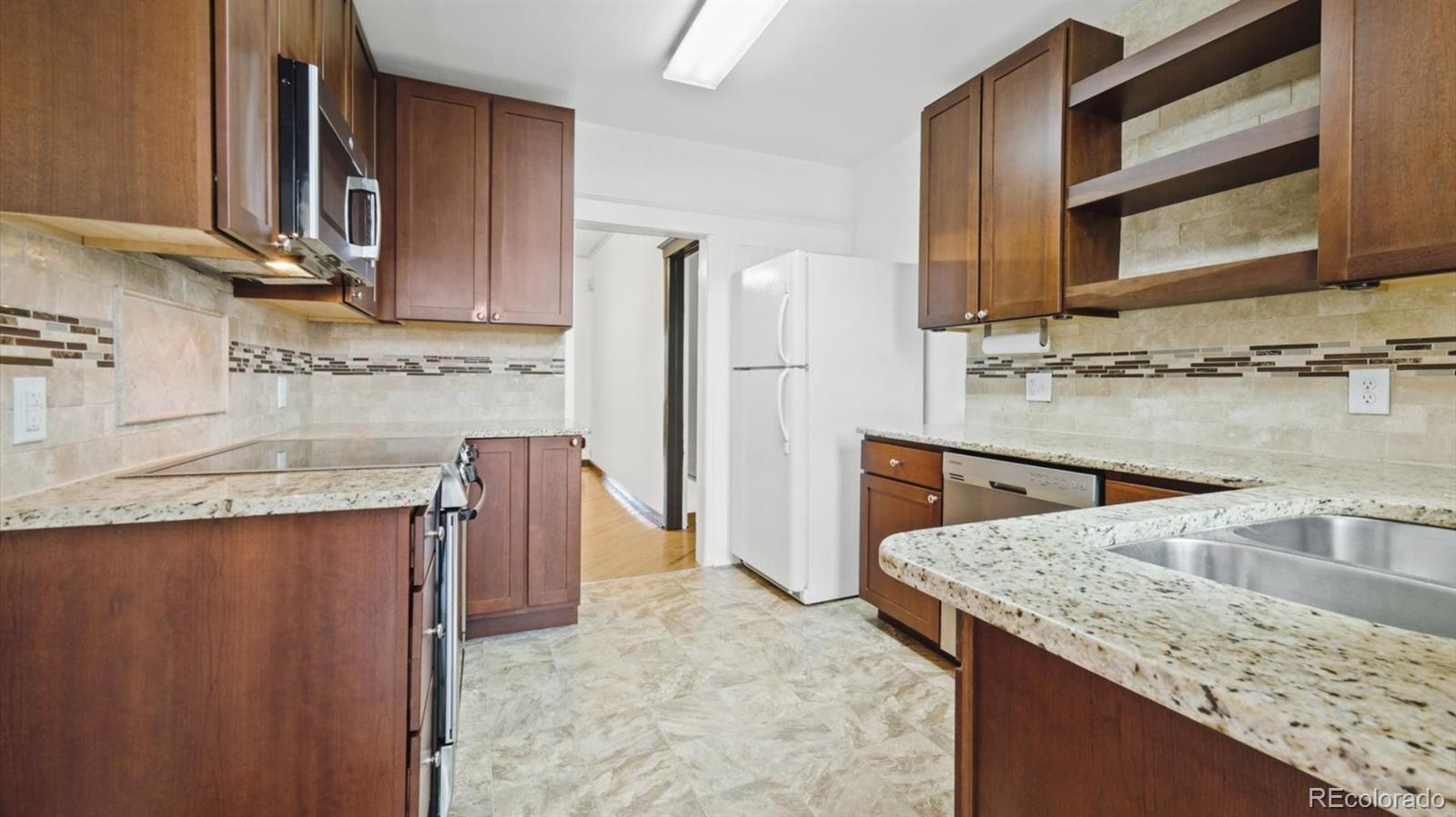 553 Logan Street Denver, CO 80203 - Photo 7 of 38 a kitchen with a sink refrigerator and cabinets