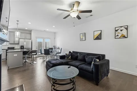 a living room with furniture a ceiling fan and a rug