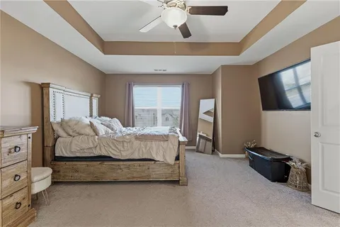 a spacious bedroom with a bed and a flat tv screen