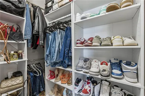 a view of walk in closet with clothes and shoes