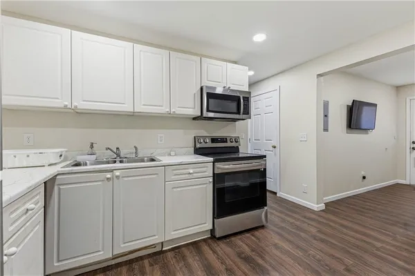 a kitchen with stainless steel appliances granite countertop a stove a sink and a microwave