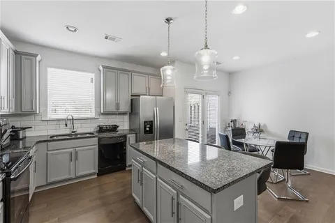 a kitchen with stainless steel appliances granite countertop a sink a stove and refrigerator