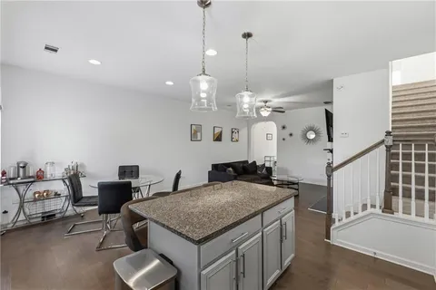 a kitchen with stainless steel appliances granite countertop a stove a sink and a living room view