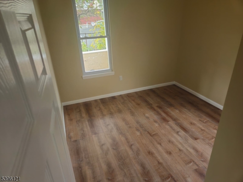 518 East 23rd Street, Unit 2R Paterson, NJ 07514 - Photo 6 of 7 a view of an empty room with wooden floor and a window