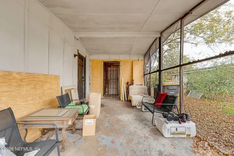 a living room with furniture a floor to ceiling window and potted plants
