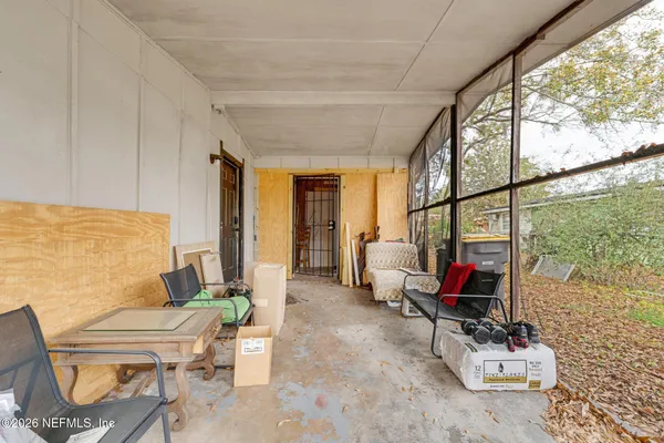 a living room with furniture a floor to ceiling window and potted plants