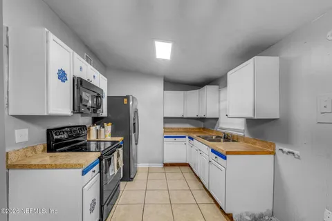 a kitchen with stainless steel appliances a refrigerator a stove a sink a counter space and cabinets