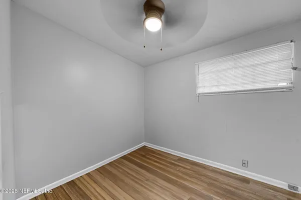 a view of empty room with wooden floor