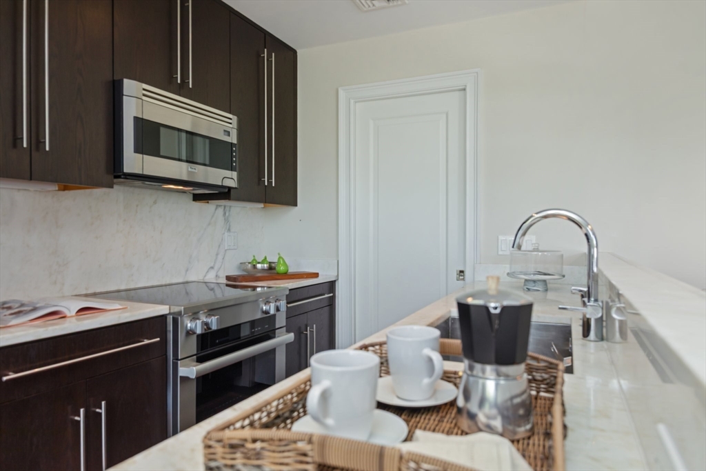56 Commonwealth Avenue, Unit PH Boston, MA 02116 - Photo 15 of 33 a kitchen with a stove and a microwave