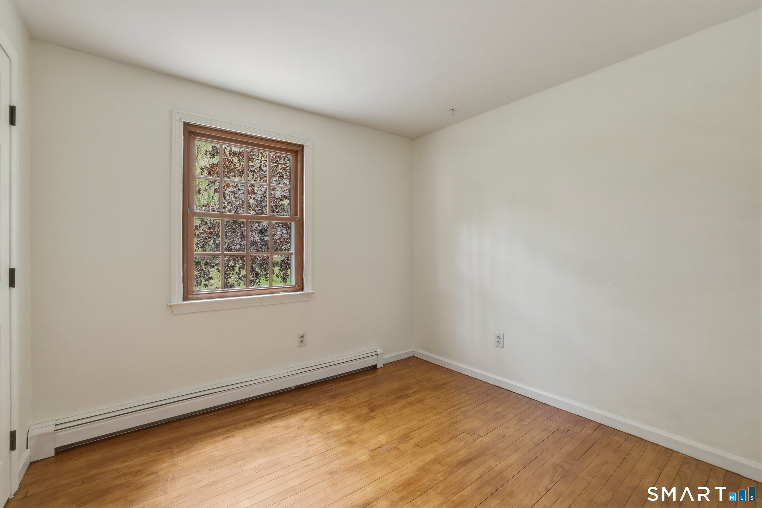 10 Salem Road Madison, CT 06443 - Photo 17 of 31 The third bedroom in this home features hardwood floors and a large window overlooking the driveway gardens.