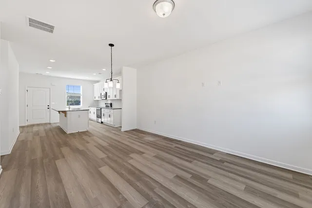 a view of a kitchen with wooden floor and a window