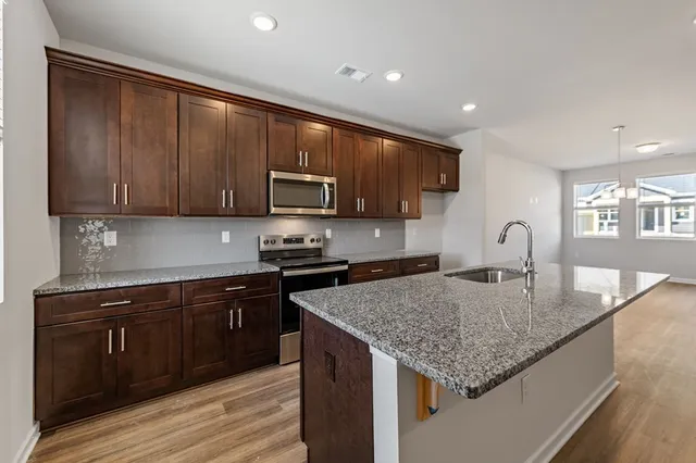 a kitchen with granite countertop a stove and a sink