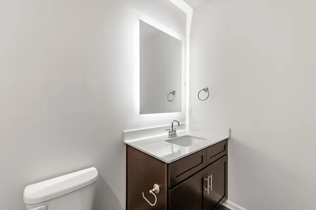 a bathroom with a toilet sink and mirror