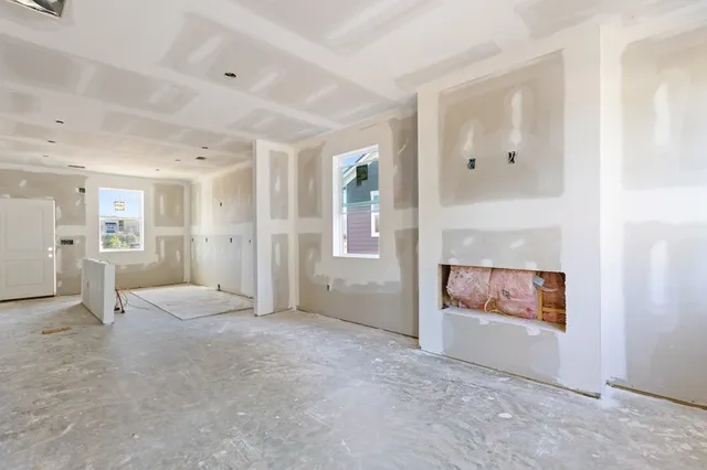 an empty room with entrance and windows