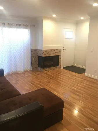 a view of kitchen and empty room with wooden floor
