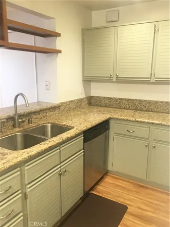 a kitchen with granite countertop a sink and cabinets