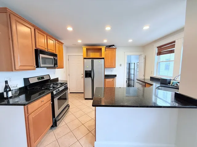 a kitchen with stainless steel appliances granite countertop a stove a refrigerator a sink a stove and island