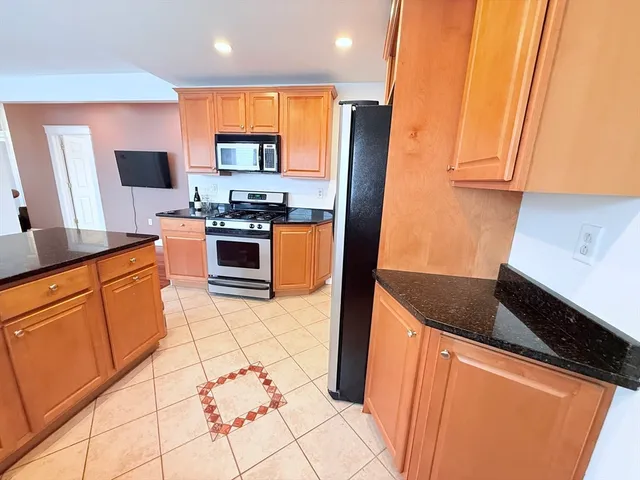 a kitchen with stainless steel appliances granite countertop a stove a sink and a microwave