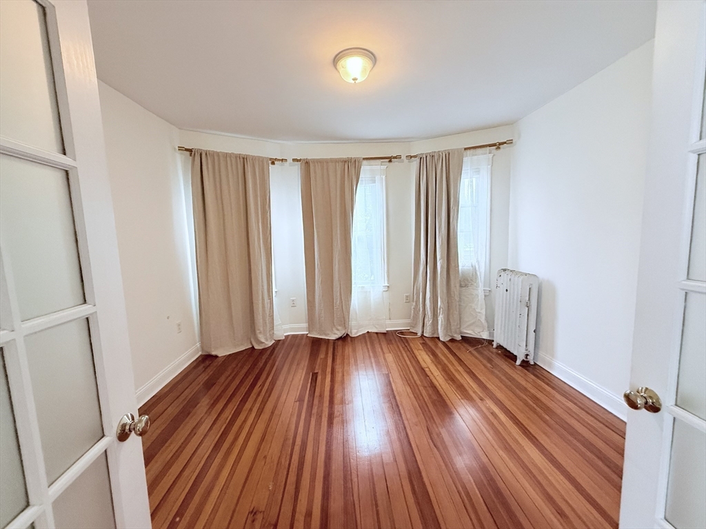 2 A Victoria Street, Unit 2A Boston, MA 02125 - Photo 6 of 13 an empty room with wooden floor and windows