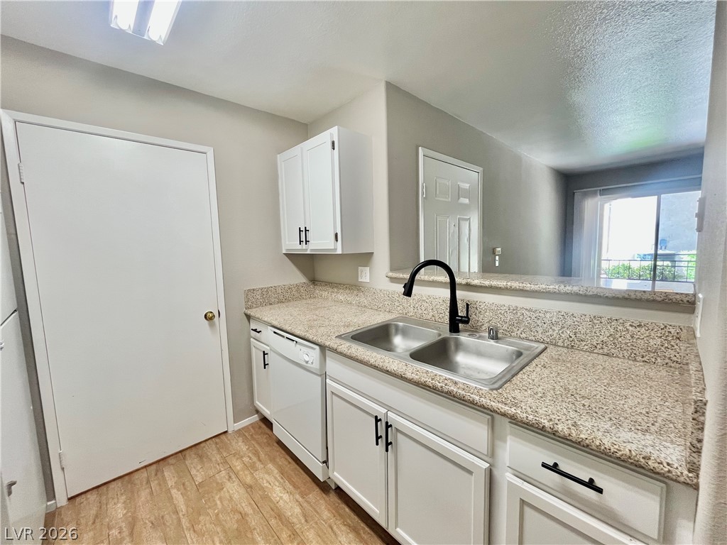 7885 West Flamingo Road, Unit 1029 Las Vegas, NV 89147 - Photo 8 of 18 A well-appointed kitchen showcasing durable granite counters and a practical double-basin sink.