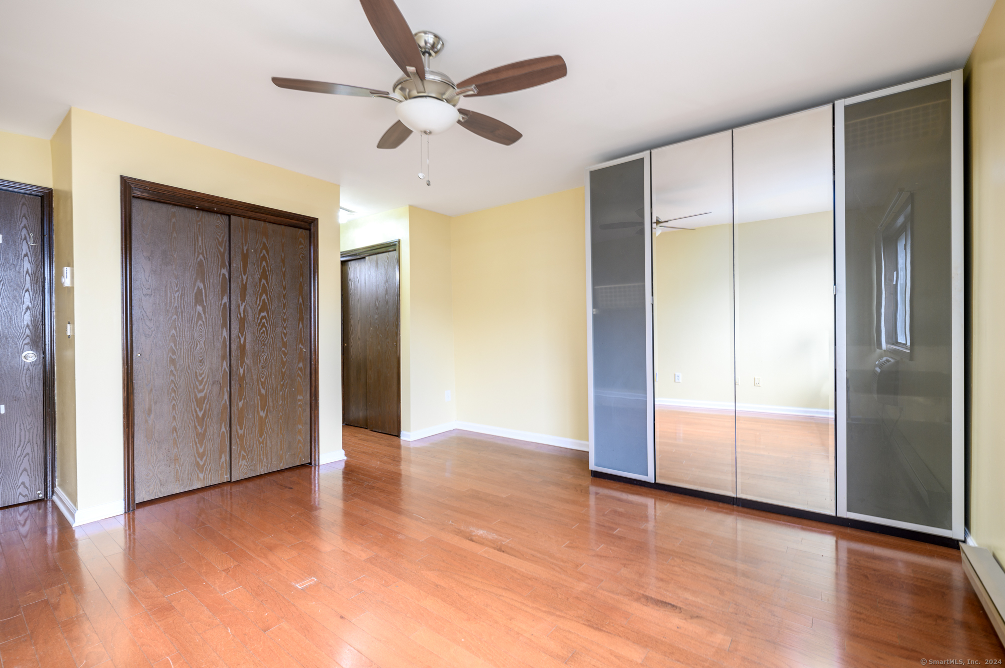 22 Radio Place, Unit 10 Stamford, CT 06906 - Photo 11 of 14 a view of an empty room with wooden floor and a ceiling fan