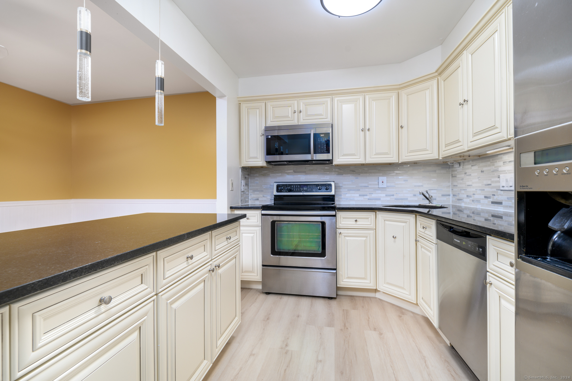 22 Radio Place, Unit 10 Stamford, CT 06906 - Photo 6 of 14 a kitchen with granite countertop white cabinets and stainless steel appliances