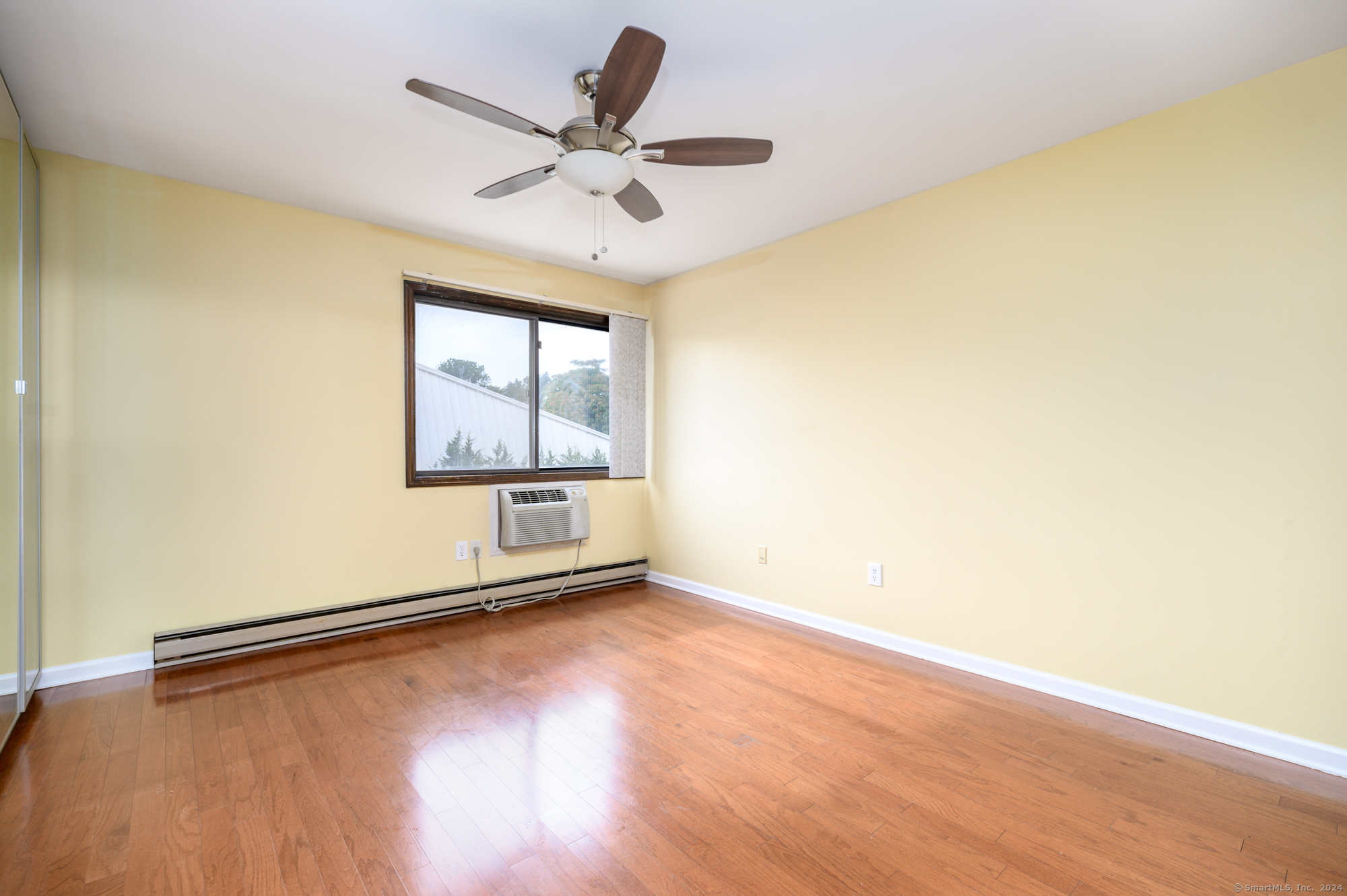 22 Radio Place, Unit 10 Stamford, CT 06906 - Photo 10 of 14 an empty room with wooden floor fan and windows
