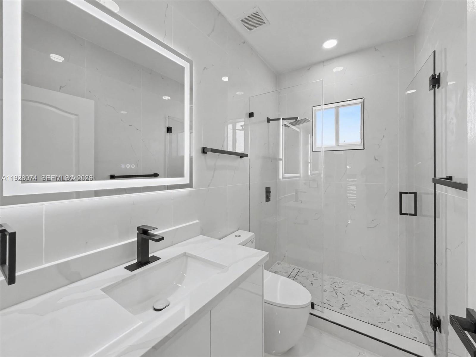 15064 Southwest 30th Terrace Miami, FL 33185 - Photo 23 of 60 a bathroom with a sink toilet a mirror and shower