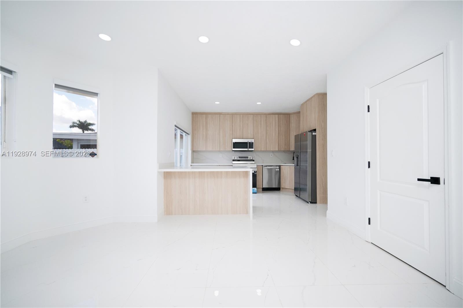 15064 Southwest 30th Terrace Miami, FL 33185 - Photo 36 of 60 a large kitchen with stainless steel appliances a refrigerator a sink dishwasher with a dining table and chairs